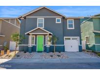 Charming two-story home showcasing modern architecture and a well-manicured front yard with a vibrant green door at 16875 N 12Th St # 33, Phoenix, AZ 85020