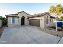 Inviting single-story home with a well-manicured lawn, neutral exterior, and a spacious driveway leading to a two-car garage at 21050 E Tierra Grande --, Queen Creek, AZ 85142