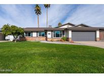 Charming single-story home with a well-manicured lawn, desert landscaping, and attached two-car garage at 2430 E Hermosa Dr, Tempe, AZ 85282
