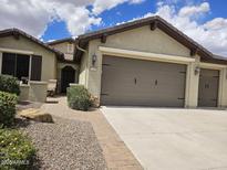 Charming single-story home with a two-car garage, desert landscaping, and a welcoming entryway at 27158 W Potter Dr, Buckeye, AZ 85396