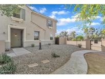 Inviting front of the two-story home featuring a low maintenance desert landscape and gated entrance at 3076 E Dunbar Dr, Phoenix, AZ 85042