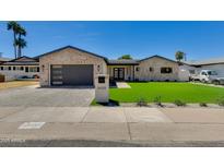 Charming single-story home featuring brick accents, lush green lawn, and modern garage door at 5425 E Avalon Dr, Phoenix, AZ 85018