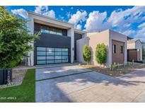 Contemporary home featuring a glass garage door, desert landscaping, and a paved driveway at 6142 E Alta Hacienda Dr, Scottsdale, AZ 85251