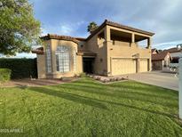 Charming two-story home featuring a well-manicured lawn and a three-car garage at 10997 E Altadena Ave, Scottsdale, AZ 85259