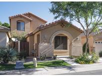 Charming tan two-story home featuring a covered front porch and well-maintained landscaping at 1950 W Park Pl, Chandler, AZ 85224
