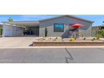 Charming home with low-maintenance front yard, covered carport, and cozy outdoor seating area with umbrella at 2400 E Baseline Ave # 228, Apache Junction, AZ 85119