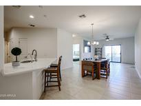 Bright, open-concept living space with modern kitchen island and dining area with outdoor access at 2511 W Queen Creek Rd # 337, Chandler, AZ 85248