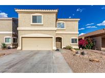 Two-story home with a two car garage, desert landscaping, and tan stucco at 337 N 103Rd Pl, Apache Junction, AZ 85120