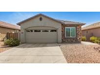 Charming single-story home features a two-car garage, neutral stucco, stone accents and low-maintenance desert landscaping at 343 S 202Nd Dr, Buckeye, AZ 85326
