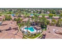 Aerial view of a sparkling community pool and hot tub amidst lush landscaping and luxurious homes at 3800 S Cantabria Cir # 1077, Chandler, AZ 85248