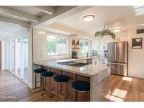 Modern kitchen featuring stainless steel appliances, granite countertops, and a breakfast bar with seating for casual dining at 4502 N 17Th Ave, Phoenix, AZ 85015