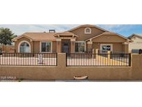 Charming single-story home with a well-maintained front yard and decorative fence at 6701 W Catalina Dr, Phoenix, AZ 85033