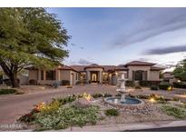 Stunning home featuring a circular driveway with water fountain and professional landscaping at 7327 E La Junta Rd, Scottsdale, AZ 85255