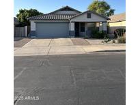 Charming single-Gathering home featuring a two-car garage, desert landscaping, and neutral color palette at 9438 E Plana Ave, Mesa, AZ 85212