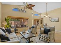 Bright living room featuring high ceilings, large windows, and stylish furnishings with a ceiling fan at 16648 W Adams St, Goodyear, AZ 85338