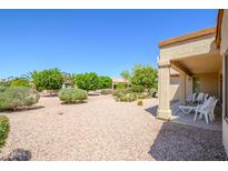 Inviting backyard featuring desert landscaping and a covered patio, perfect for relaxing and entertaining at 19472 N Marble Canyon Ct, Surprise, AZ 85374