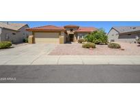 Charming single-story home featuring a well-maintained yard, a two-car garage, and a beautiful red tile roof at 19472 N Marble Canyon Ct, Surprise, AZ 85374