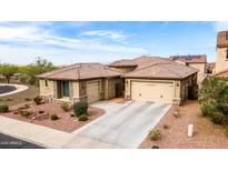Stunning home with a two-car garage, beautiful landscape, and a well-manicured lawn under a sunny blue sky at 25540 N 103Rd Dr, Peoria, AZ 85383