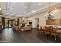 Open-concept living room boasts dark wood floors, a stone fireplace, and seamless access to the outdoor patio at 26156 N 88Th Way, Scottsdale, AZ 85255