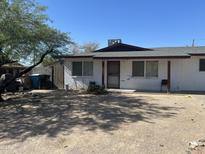 Modest home featuring a low, gabled roof and a gravel front yard against a bright, clear blue sky at 520 W Mcneil St, Phoenix, AZ 85041