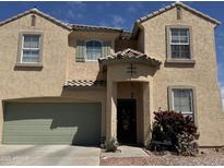 Charming two-story home featuring a quaint front door with a covered entryway and a well-maintained front yard at 703 N Redwood Ln, Buckeye, AZ 85326