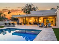 Inviting backyard pool with travertine decking, outdoor kitchen, and comfortable lounge area perfect for entertaining at 8501 E Appaloosa Trl, Scottsdale, AZ 85258