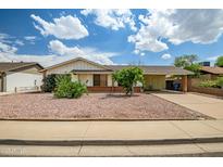 Charming single-story home featuring low maintenance desert landscaping and a covered carport at 8741 W Osborn Rd, Phoenix, AZ 85037
