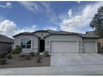 Charming single-story home with a three car garage, desert landscaping, and a neutral color palette at 10736 W Swayback Pass, Peoria, AZ 85383