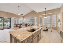 Open-concept kitchen with granite island, modern appliances, and a breakfast nook at 10907 E Bella Vista Dr, Scottsdale, AZ 85259