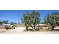 Charming single story home with mature trees, well-manicured lawn, and a two car garage at 21218 N Aurora Dr, Sun City West, AZ 85375