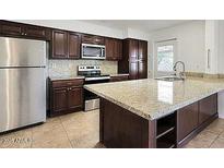Well-equipped kitchen with stainless steel appliances, granite counters, and custom cabinetry at 233 E Cairo Dr, Tempe, AZ 85282