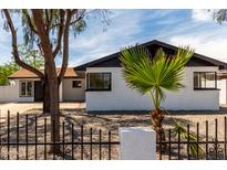 Charming home with white brick, black trim, desert landscaping, and a wrought iron fence at 3802 N 48Th Dr, Phoenix, AZ 85031