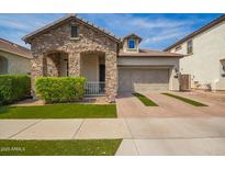 Charming stone accented home featuring a 2 car garage and manicured lawn at 10452 E Natal Ave, Mesa, AZ 85209