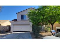 Two-story home featuring a two-car garage, low maintenance landscaping, and a tile roof at 10521 W Toronto Way, Tolleson, AZ 85353