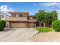 Two-story home with a well-manicured lawn, three car garage and brick accents at 15910 W Shangri La Rd, Surprise, AZ 85379
