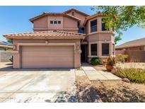 Two-story home with a neutral color scheme, well-maintained landscaping, and a two-car garage at 16527 N 71St Dr, Peoria, AZ 85382