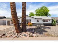 Charming single-story home with black and white trim, desert landscaping, and two large palm trees in front at 2914 W Marlette Ave, Phoenix, AZ 85017