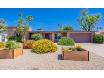 Charming home with desert landscaping and colorful flowering bushes in planter boxes at 3823 E Poinsettia Dr, Phoenix, AZ 85028
