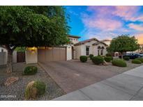 Charming home with a two-car garage, beautiful landscaping, and a brick driveway at 3872 E Jude Ln, Gilbert, AZ 85298