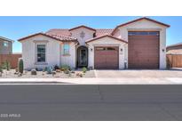 Charming single-story home with desert landscaping, tile roof and a three-car garage at 40725 W Hall Dr, Maricopa, AZ 85138