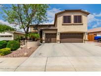 Two story home featuring a three car garage, desert landscaping and a mature shade tree at 5910 W Blue Sky Dr, Phoenix, AZ 85083