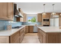 Well-lit kitchen boasts custom cabinetry, stainless steel appliances, and a center island with quartz countertop at 14802 N 3Rd Ave, Phoenix, AZ 85023