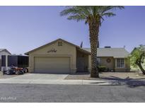 Charming single-story home with a two-car garage, gravel yard and a mature palm tree at 1623 E Krystal St, Casa Grande, AZ 85122
