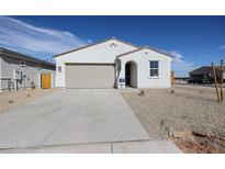 Charming single-story home featuring a desert-style gravel yard, a two-car garage and a welcoming arched entryway at 22085 N Rummler Ln, Maricopa, AZ 85138