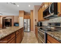 Modern kitchen featuring stainless steel appliances, granite countertops, and ample cabinet space for storage at 3152 E San Pedro Ct, Gilbert, AZ 85234