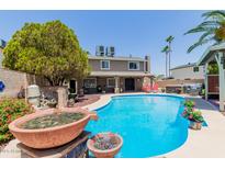 Inviting backyard oasis with a sparkling pool, hot tub and lush landscaping, perfect for outdoor entertaining at 3377 W Grandview Rd, Phoenix, AZ 85053
