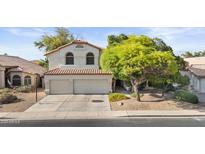 Charming two-story home with a well-manicured lawn and a two-car garage at 630 W Navarro Ave, Mesa, AZ 85210