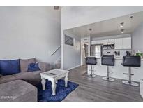 Inviting living room featuring a cozy sofa, counter seating, and open layout to the kitchen and stairs at 8055 E Thomas Rd # D111, Scottsdale, AZ 85251