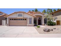 Charming single-story home featuring a terracotta tile roof, stucco exterior, and well-maintained desert landscaping at 10952 S Desert Lake Dr, Goodyear, AZ 85338