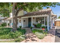 Charming home featuring a tile roof, lush landscaping, and a welcoming brick pathway leading to the front door at 1306 W Heatherbrae Dr, Phoenix, AZ 85013